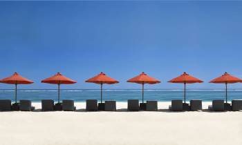 a row of beach chairs and an umbrella