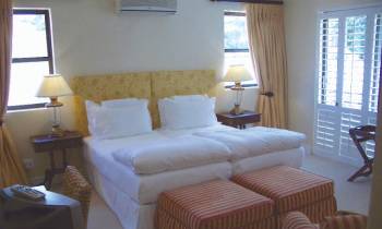 a bedroom with a bed and a chair in a room