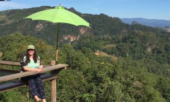 a person sitting on a bench with a mountain in the background