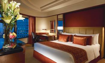 a bedroom with a bed and desk in a hotel room