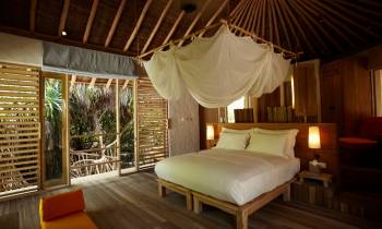 a bedroom with a bed and a chair in a room