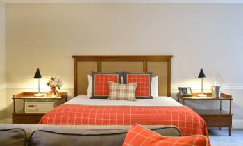 a bedroom with a large red chair in a room