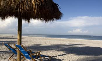 a person sitting on top of a sandy beach
