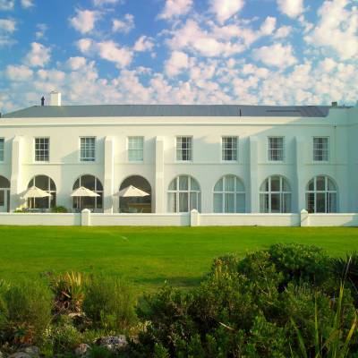 a large white building with a grassy field