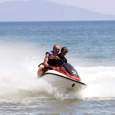 a man riding on the back of a boat in a body of water