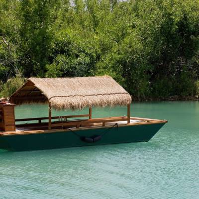 a small boat in a body of water with Raja Ampat Islands in the background