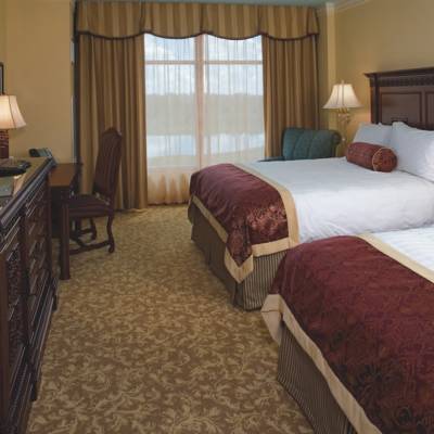 a bedroom with a bed and desk in a hotel room