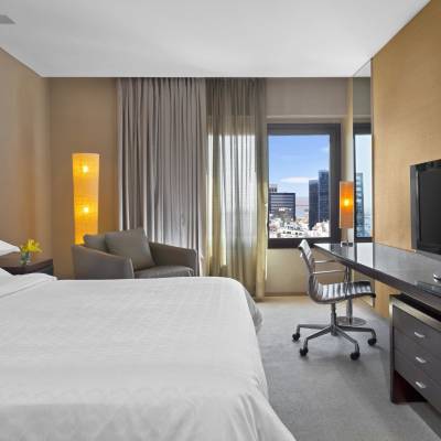 a bedroom with a bed and desk in a hotel room