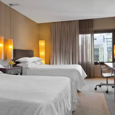a bedroom with a bed and desk in a hotel room