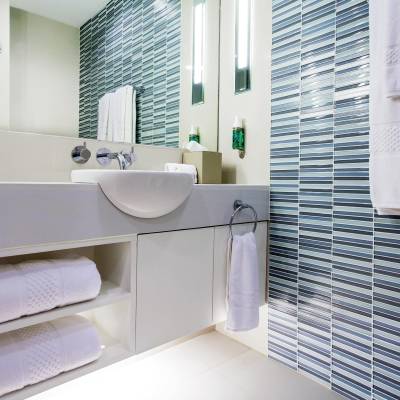 a white sink sitting under a mirror