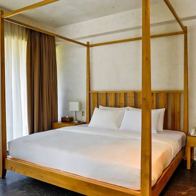 a bedroom with a bed and a chair in a room