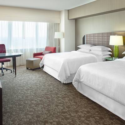 a bedroom with a bed and desk in a hotel room