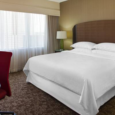 a bedroom with a bed and desk in a hotel room