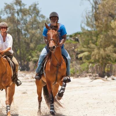 a man riding a horse on a beach