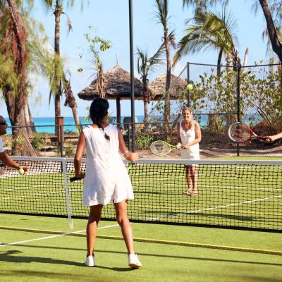a group of people on a court with a racket