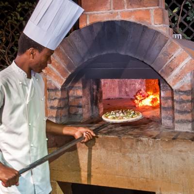 a man cooking hot dogs on a grill