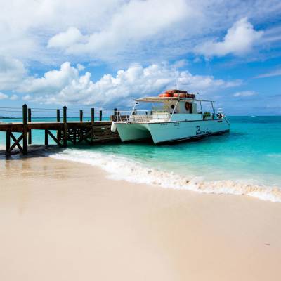 a boat sitting on top of a sandy beach next to the ocean
