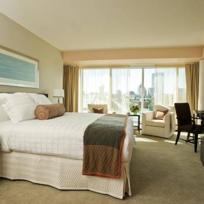 a bedroom with a bed and desk in a hotel room