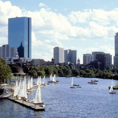 a small boat in a body of water with a city in the background
