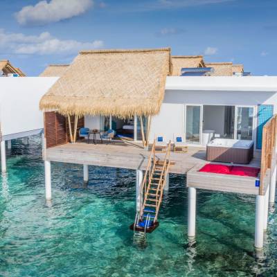 a group of lawn chairs sitting next to a pool of water