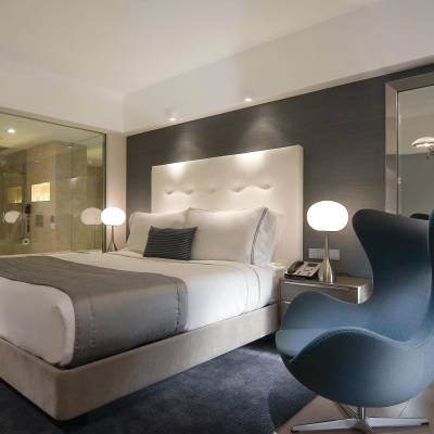 a bedroom with a bed and a chair in a room
