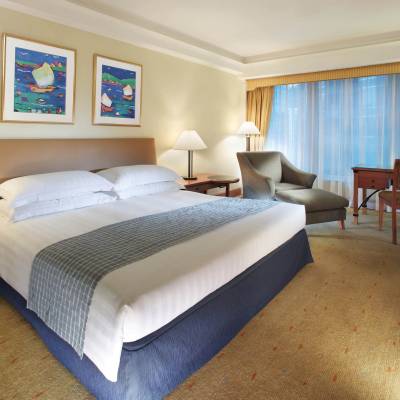 a bedroom with a bed and desk in a hotel room