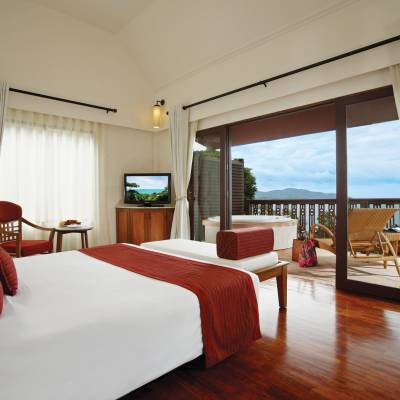 a bedroom with a bed and a chair in a room