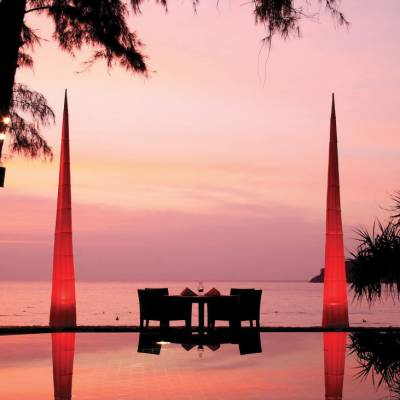 a sunset over a body of water next to a palm tree