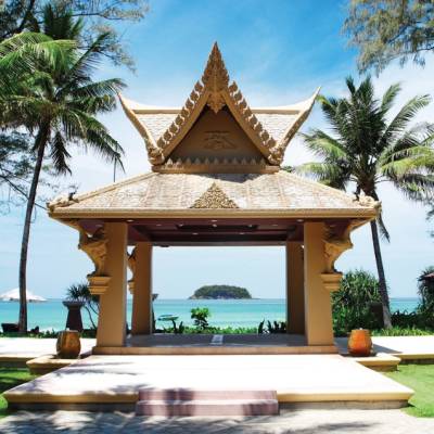 a small clock tower in front of a palm tree