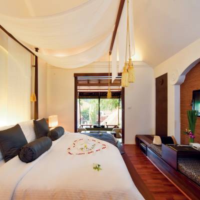 a bedroom with a bed and desk in a hotel room
