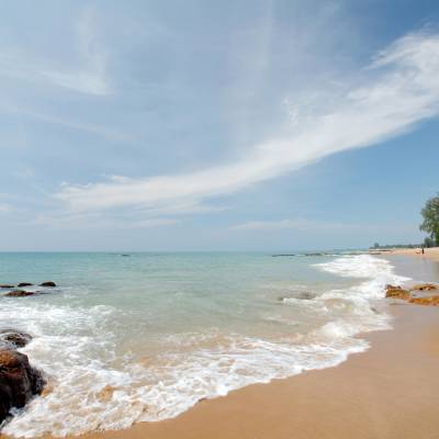 a sandy beach next to a body of water
