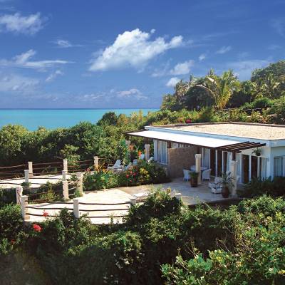 a house with bushes in front of a body of water