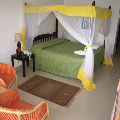 a bedroom with a bed and a chair in a room