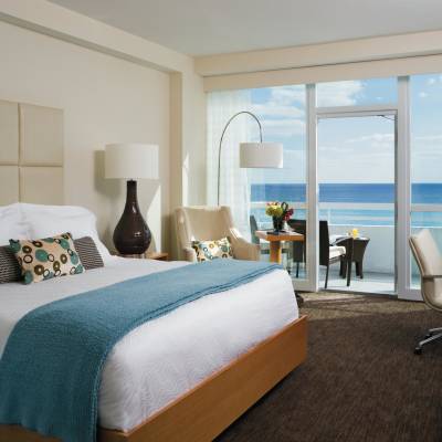 a bedroom with a bed and desk in a hotel room
