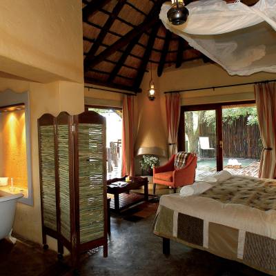 a bedroom with a bed and a chair in a room