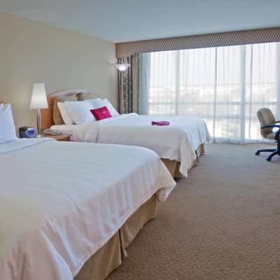 a bedroom with a bed and desk in a hotel room
