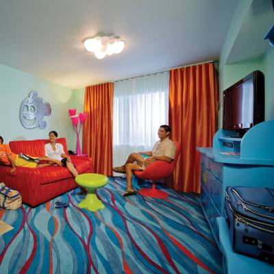 a bedroom with a bed and a person standing in a room