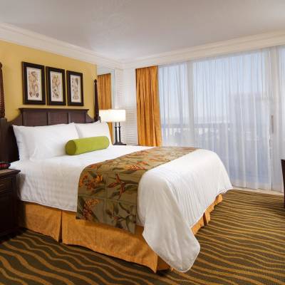 a bedroom with a bed and desk in a hotel room