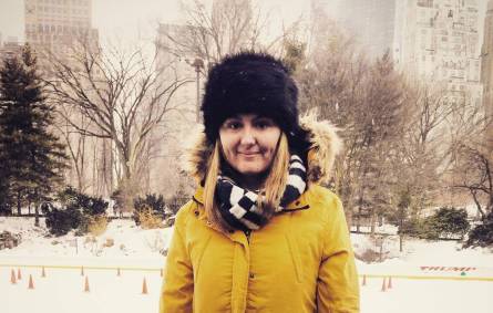 a person wearing a yellow jacket standing in the snow