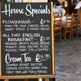 House Special menu board with a street cafe or restaurant in the background