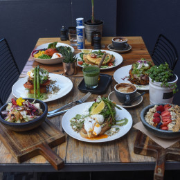 Gedeckter Frühstückstisch mit Tassen Kaffee und verschiedenen australischen Frühstücksgerichten im Melbourne Cafe, Australien