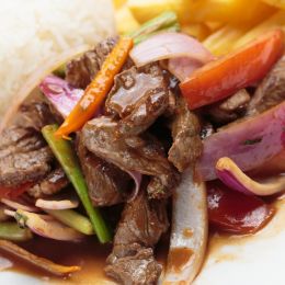Peruvian food lomo saltado A salted beef with tomatoes, onion, fried potatoes and rice