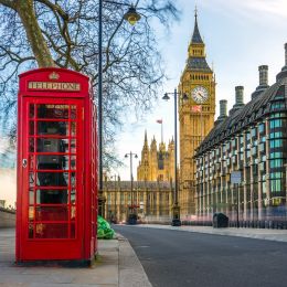 The iconic british old red telephone box with the Big Ben at background in the center of London