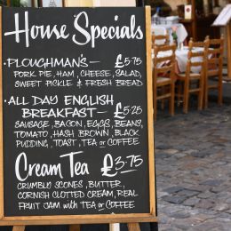 House Special menu board with a street cafe or restaurant in the background