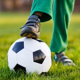 Boy stepping on a football