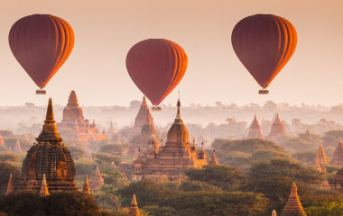 Mehrere rote Heißluftballons schweben über Bagan in Myanmar