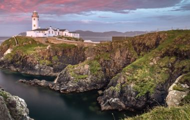 Enchanting Travels UK & Ireland Tours Donegal, Ireland. Fanad head at Donegal, Ireland with lighthouse at sunset. Colorful sky, mountains and sea