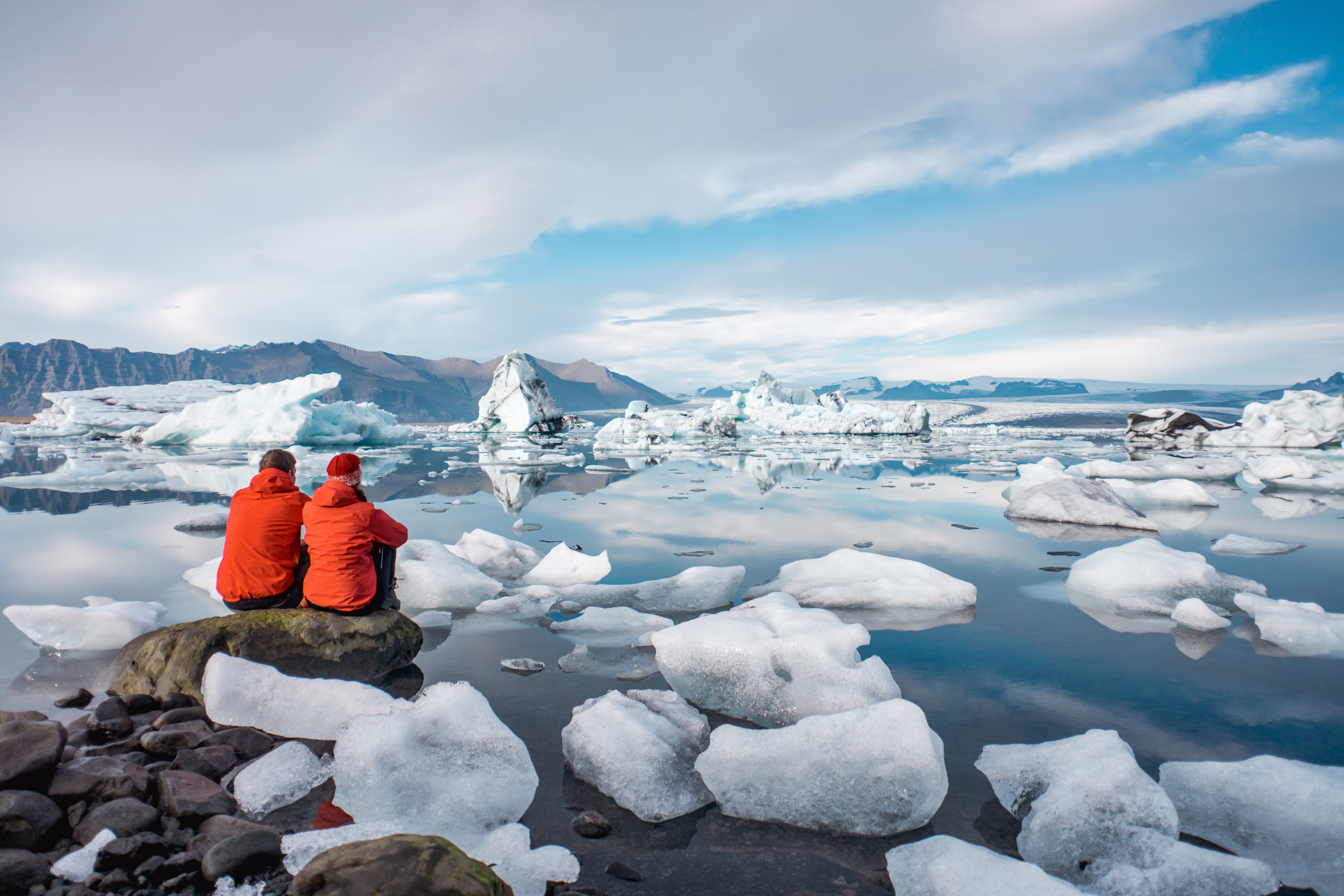 A young couple in glacier lagoon in Iceland. Iceland travel guide