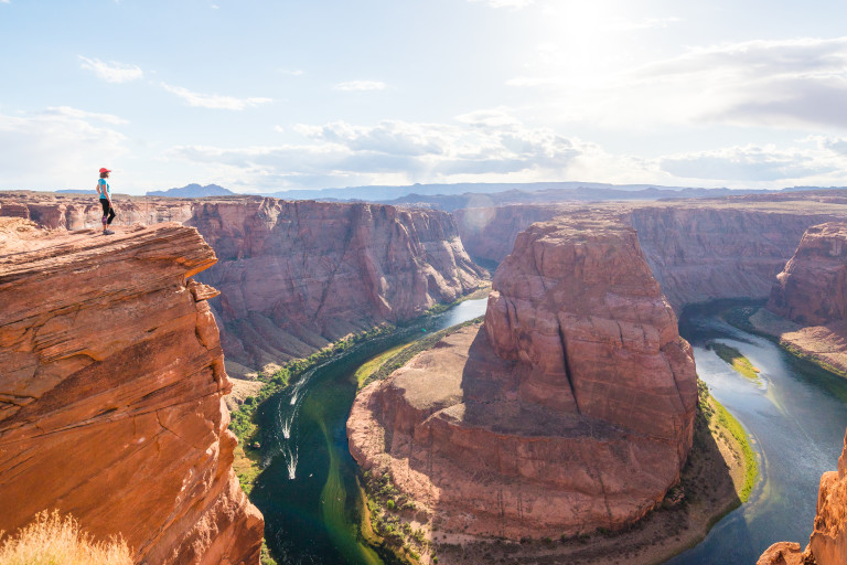 Woman stands over Horseshoe Bend, Grand Canyon