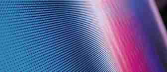 A close-up of a digital screen displaying a vibrant gradient pattern of small blue and red dots. The dots create an abstract, wave-like design as the colors blend seamlessly together, giving a sense of movement and fluidity. The focus is on the texture of the pixels.